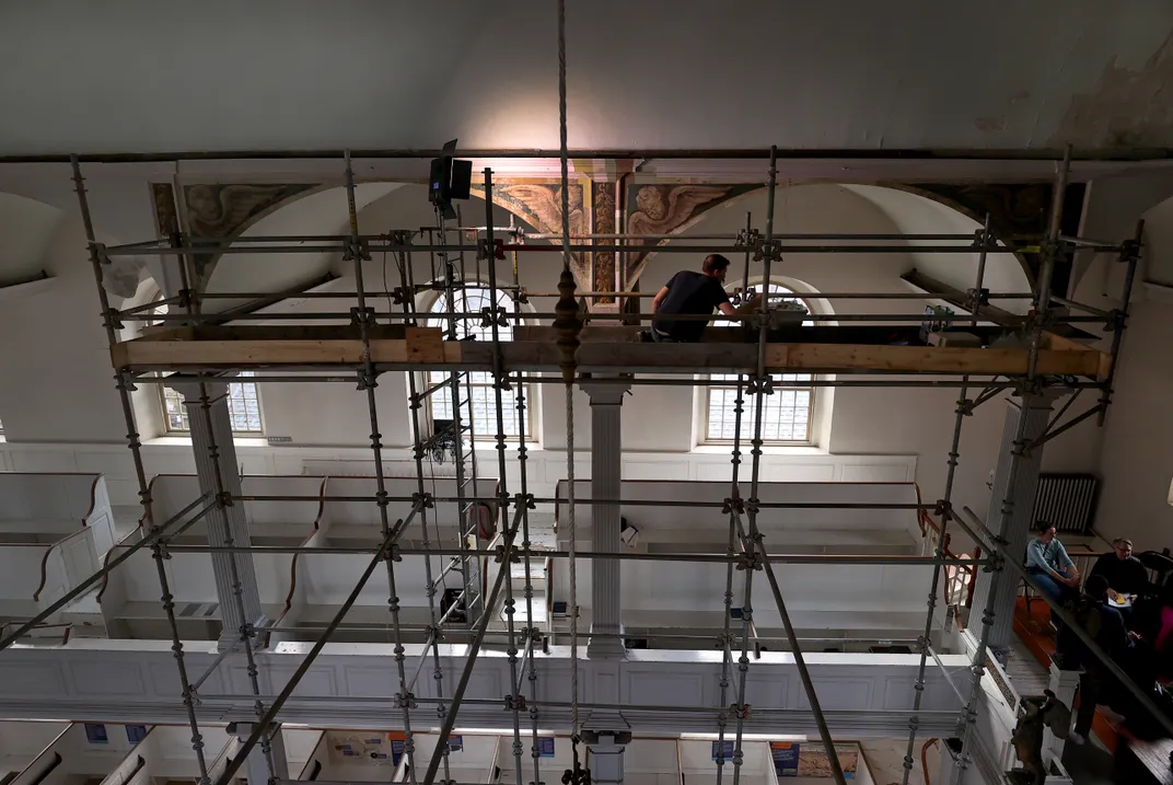 Scaffolding in front of a wall with some windows