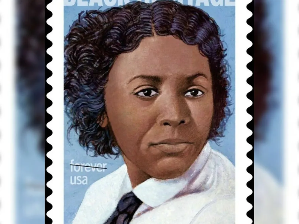 A stamp featuring a portrait of Edmonia Lewis, a Black woman with cropped wavy hair in a white shirt and black tie, on a blue background