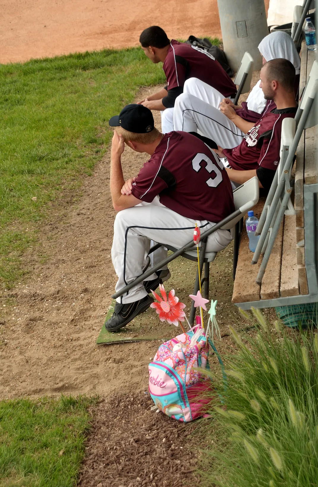 baseball players sit watching the game