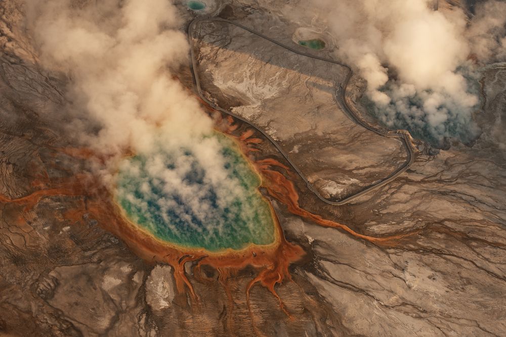 From above, Midway Geyser Basin unfurls in vivid color—Grand Prismatic’s turquoise core and fiery microbial rings glowing through drifting steam. Captured from my plane, Yellowstone’s geothermal landscape reveals its otherworldly patterns.