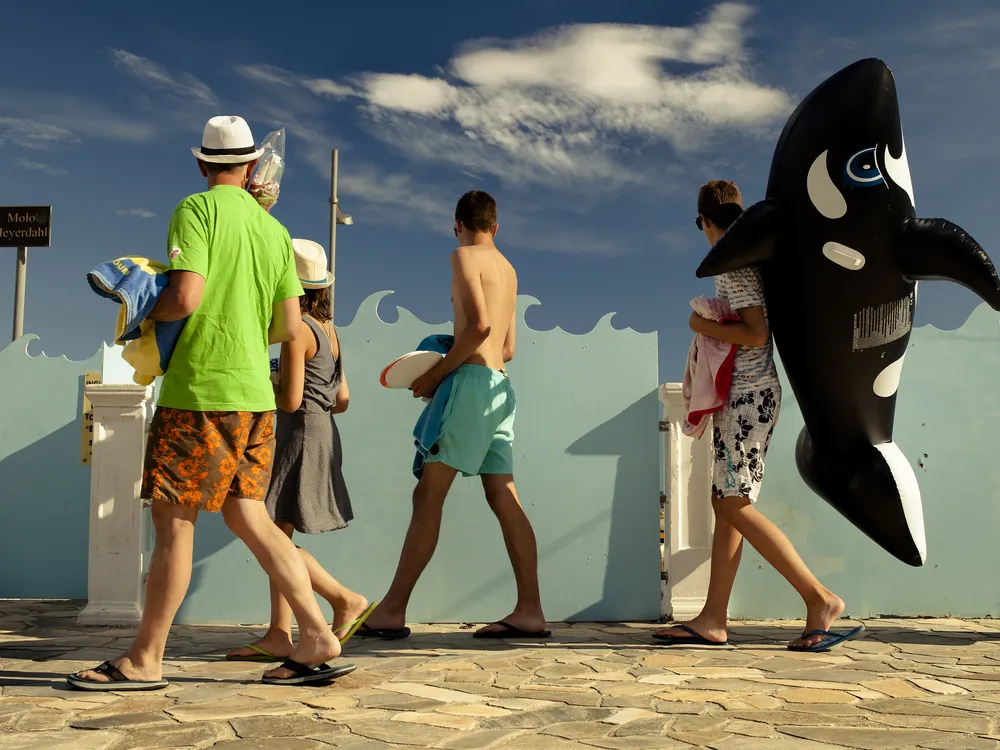 Family headed to beach holding orca inflatable