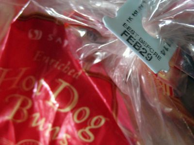 A tag sealing a bag of hot dog buns displays a best before date of February 29