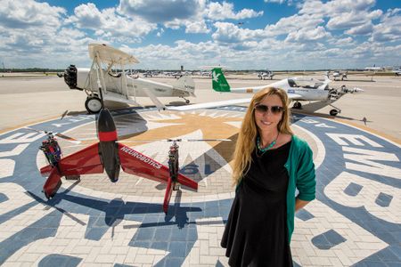 Embry-Riddle professor Carolina Anderson with three generations of aircraft on campus. The daughter of a pilot, she flies her own daughters to work with her, hoping to nurture a third flying generation in her own family.