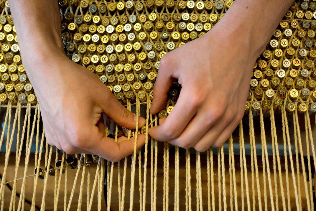 A rug made by weaving together thousands of used bullet casings