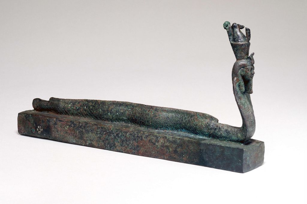 Small metal box topped with a figurine