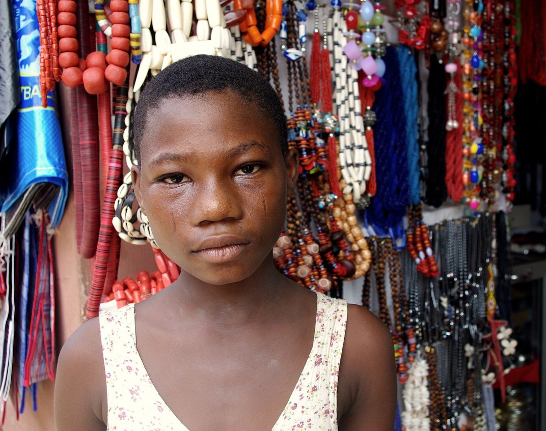 Girl on a market in Lagos, Nigeria helping out at her mother's
