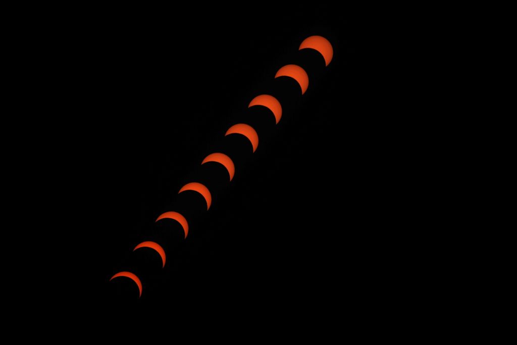 A composite image showing multiple phases of an eclipse as the moon gradually covers the sun