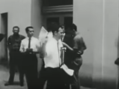 Lee Harvey Oswald, center, handing out fliers. According to a conspiracy theory floated by the National Enquirer, the unidentified man on the left wearing a black tie is the father of Senator Ted Cruz.