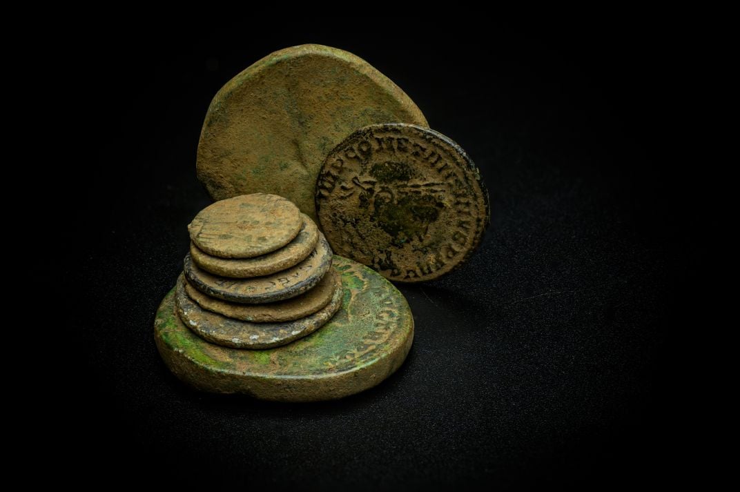 a pile of rusted ancient coins with Roman markings