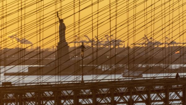Lady Liberty and the New Jersey docks silhouetted by the setting sun thumbnail