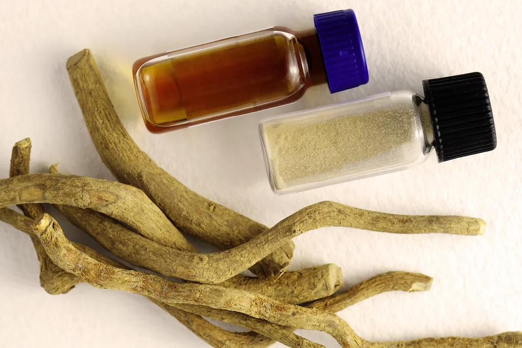 substance in small vials and a pile of roots on a white surface