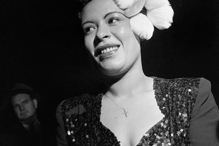 Jazz singer Billie Holiday wears a large white flower in her hair for a performance in New York City.