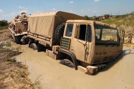 Soldiers use an M88A2 Hercules Recovery Vehicle to pull a truck from a deep puddle of mud during training. Soil moisture data from a NASA satellite could help prevent trucks getting stuck in the first place.