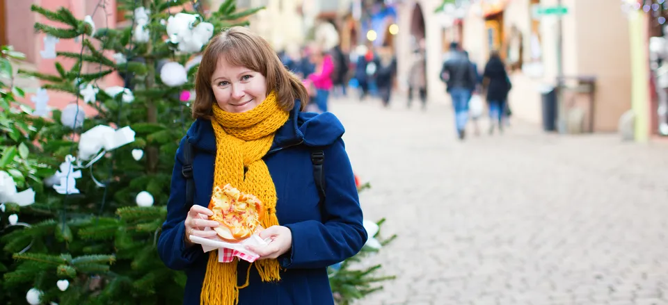  Traveler enjoying a pretzel in Strasbourg during the holidays 