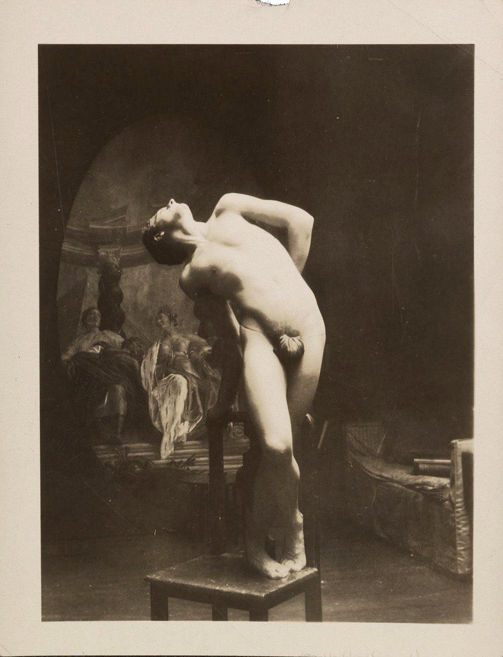 Photograph of an artists' model posing on a chair