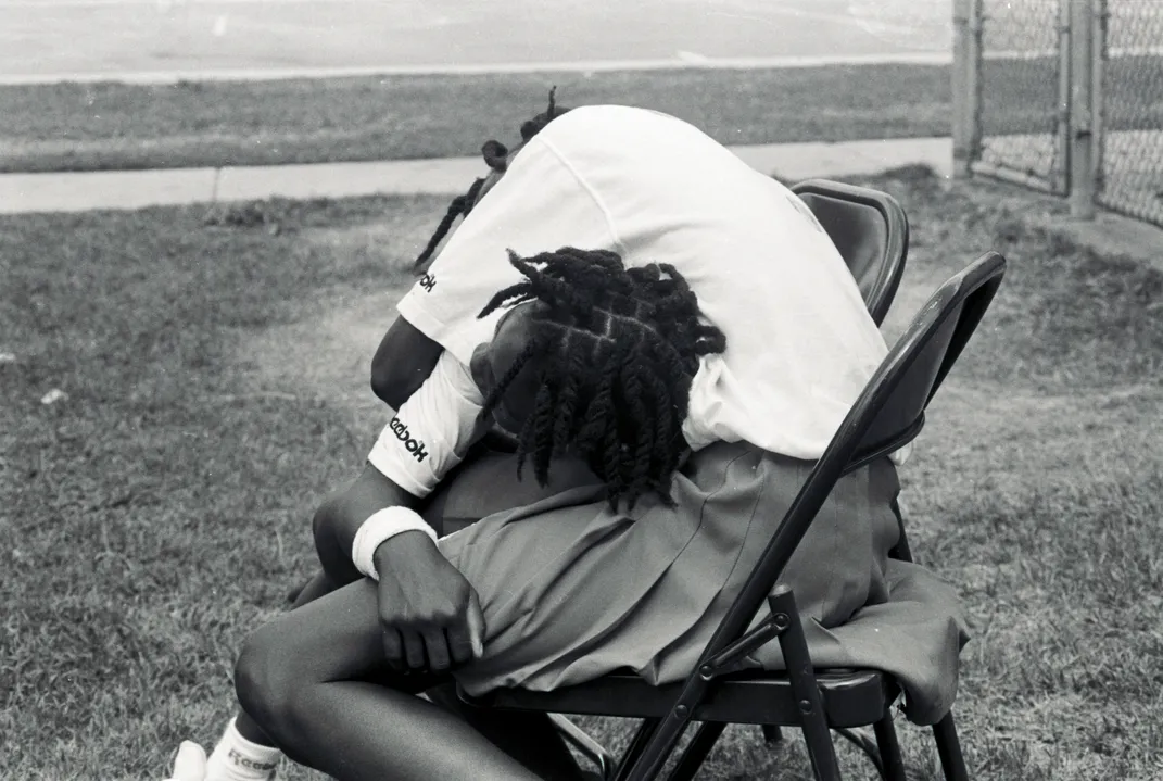 Serena leans on Venus' lap, while Venus leans over Serena's back to embrace her