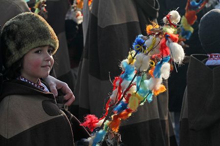 A young girl lightly pats the backs of others with a survachka on Christmas Day in Bulgaria.