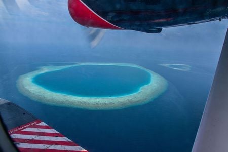The ring-shaped coral islands known as atolls, like this one in the Maldives Islands in the Indian Ocean, may trace their formation to sea levels repeatedly rising and falling over hundreds of thousands of years, geologists say.