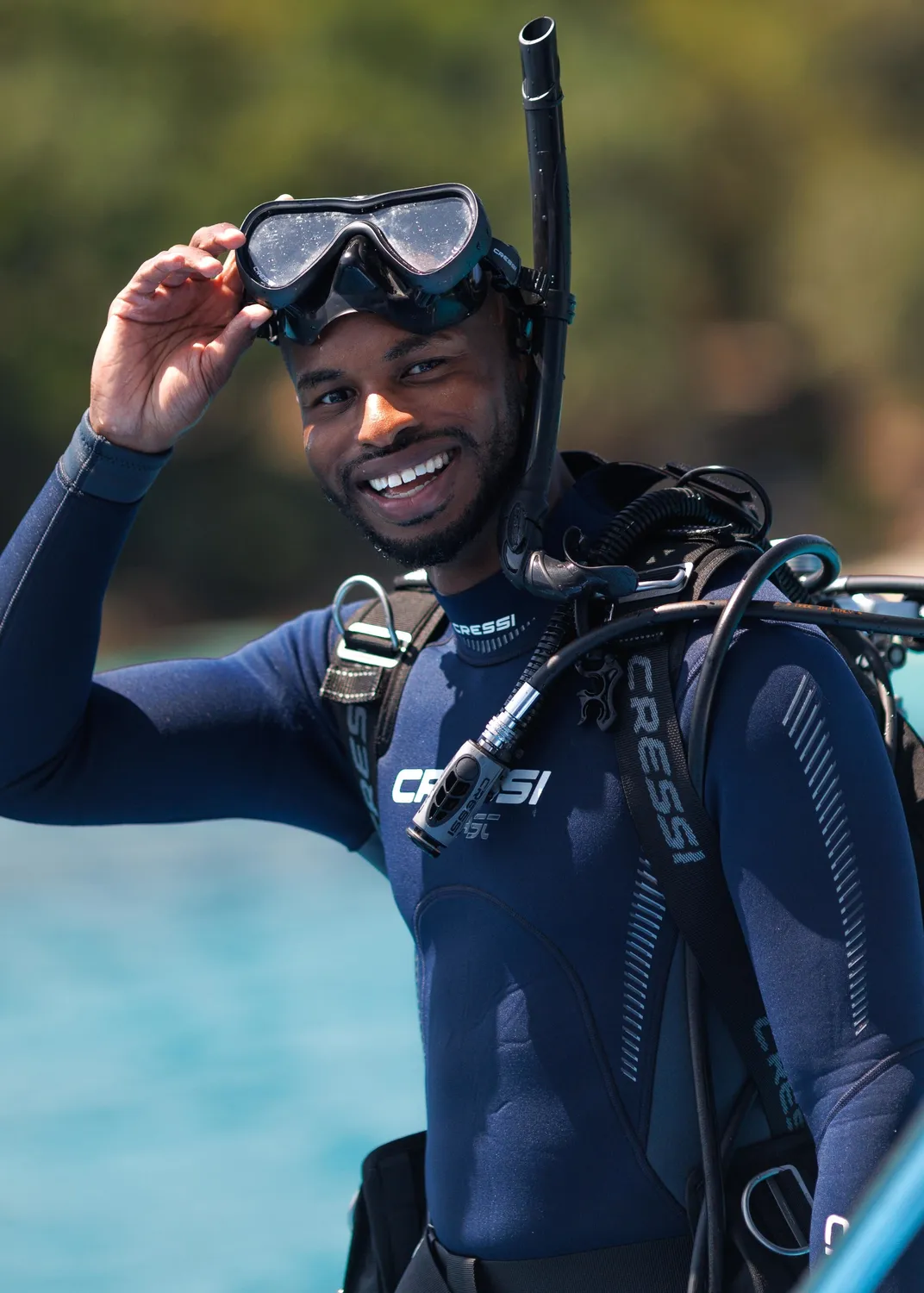 A smiling Black man wearing scuba diving gear