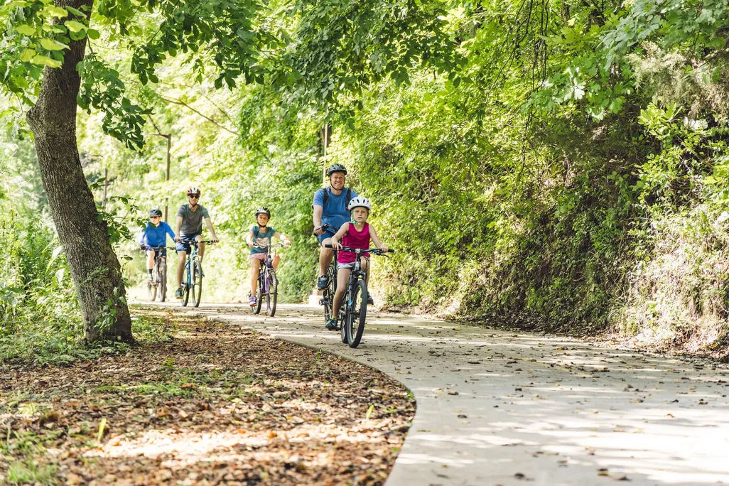 Family riding bikes on paved trail