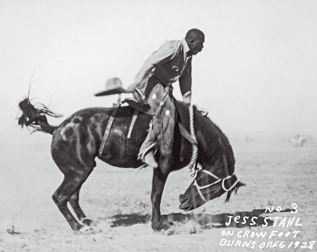 A rider holds onto a bucking horse