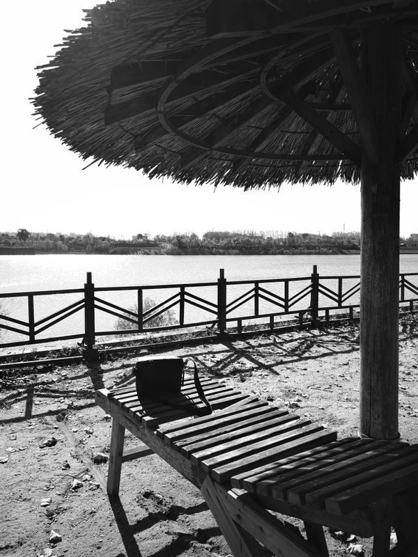 A bench under a Thatched pavilion thumbnail