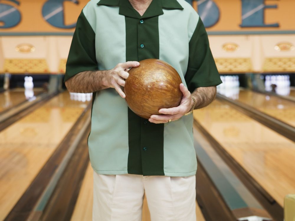 a portrait of a bowler holding a bowling ball