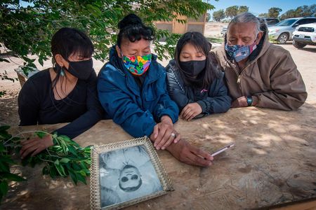 The Covid-19 pandemic has exacted a heavy toll on Native American communities. In this May 2020 image, Navajo elder Emerson Gorman (R) sits with his (L-R) daughter Naiyahnikai, wife Beverly and grandchild Nizhoni near the Navajo Nation town of Steamboat in Arizona.