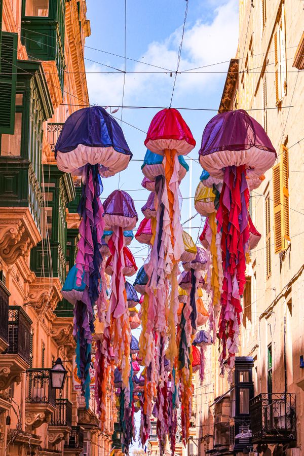 Colorful parachute jellyfish hang in the narrow Valletta street thumbnail