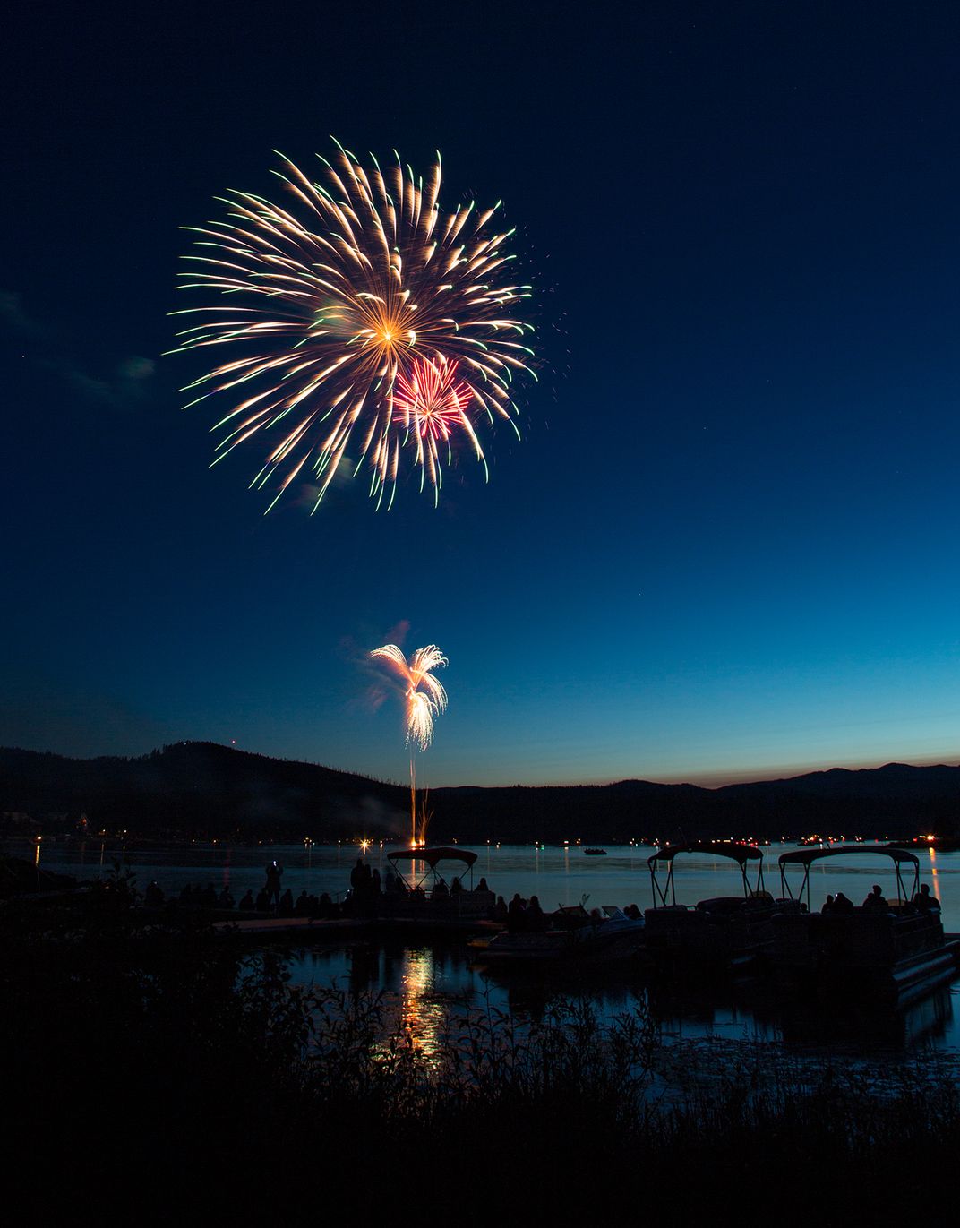 July 4th fireworks over Seeley Lake, Montana with spectators at marina Smithsonian Photo