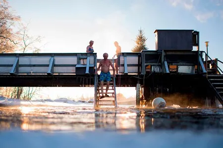 With air temperature at -17 degrees Celsius and water at 1 degree Celsius, Finns take a dip in an unfrozen hole of water after a sauna session in Vaasa, Finland.
