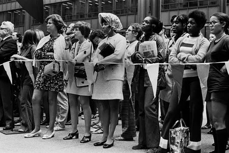 Women stand together behind a rope barrier at the Women’s March for Equality.