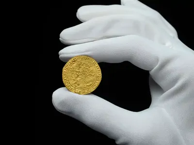 A 14th-century gold coin found by a metal detectorist in England sold for $185,000 at auction on Tuesday.