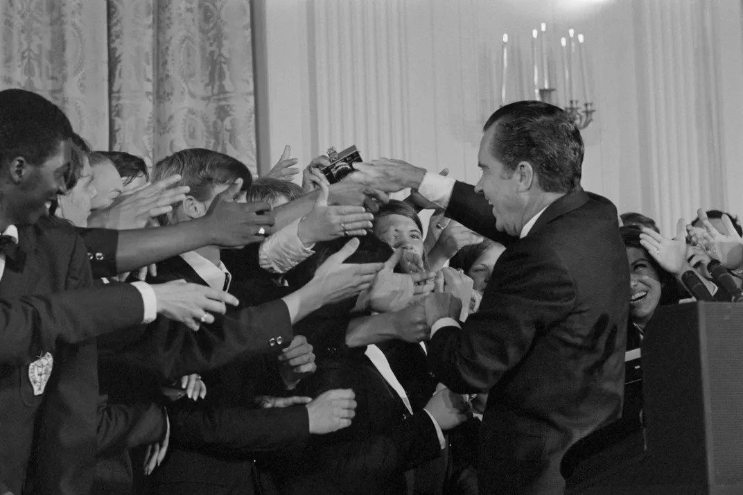 boys reaching outstretched hands to Nixon