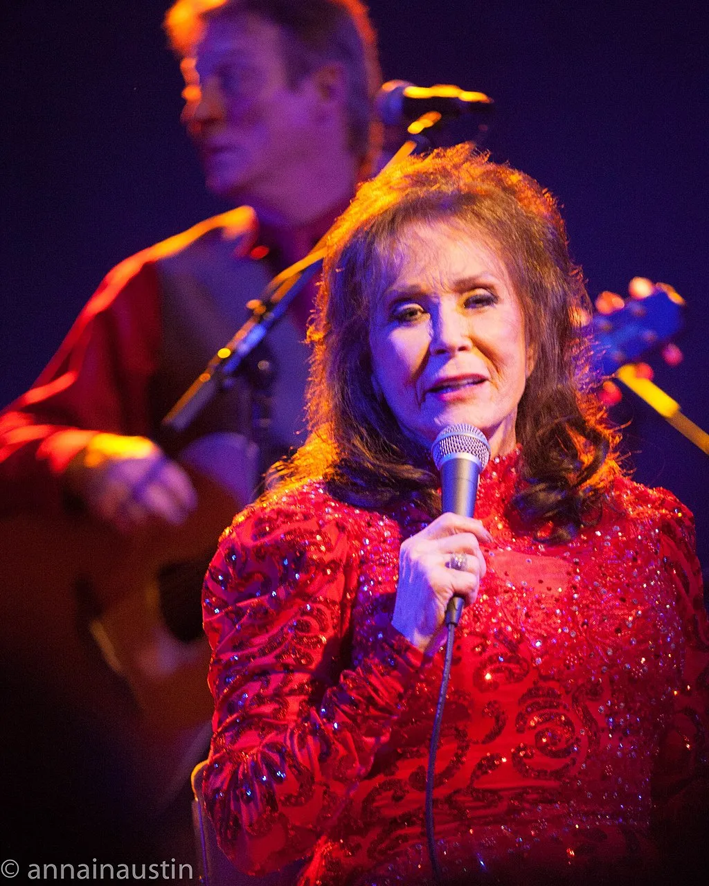 Loretta Lynn singing in a red dress
