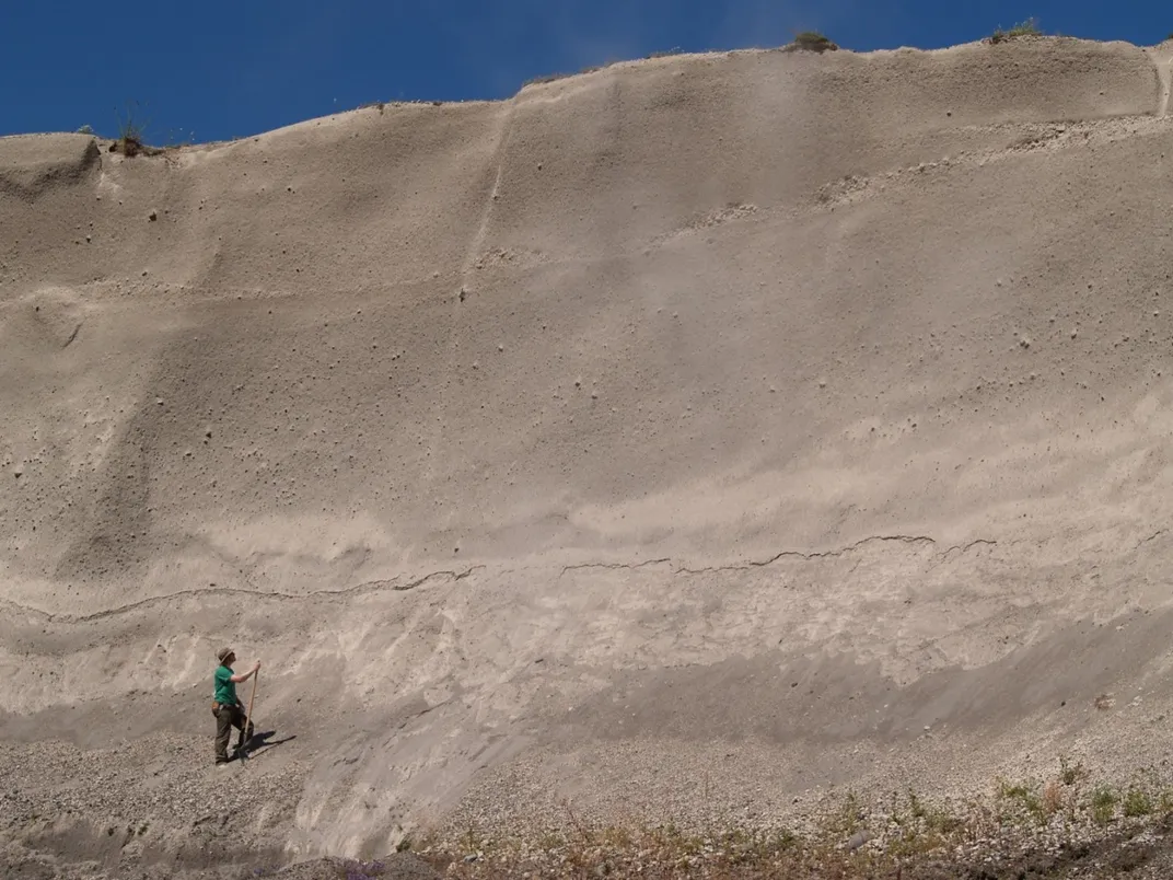 A person standing in the mouth of a volcano.