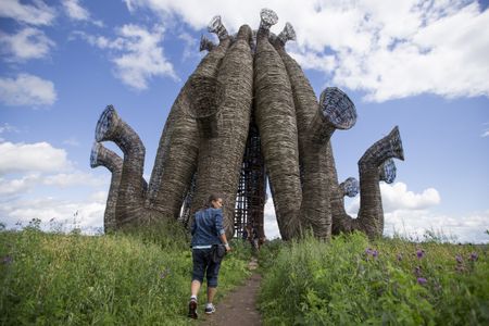 A curious visitor walking toward the Bobur artwork at the tenth Archstoyanie festival.
