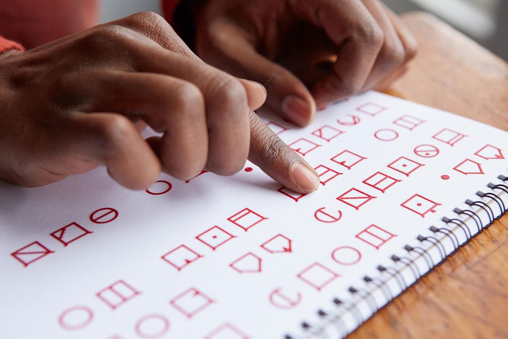 Hands reading tactile font