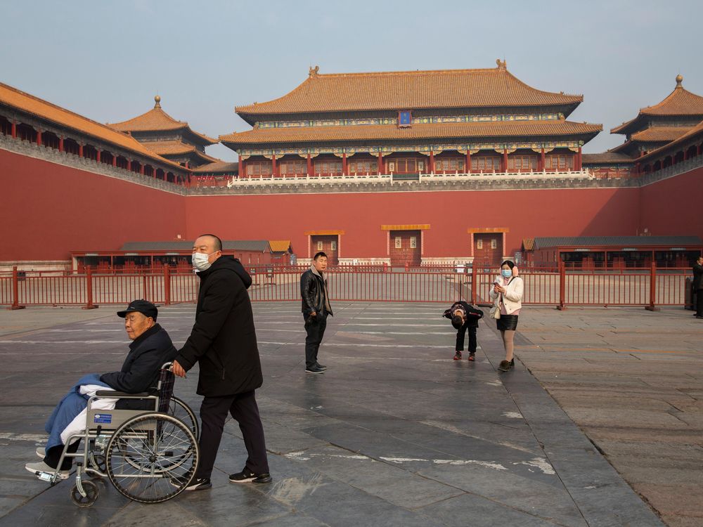 People walk past closed entrance of the Forbidden City in Beijing.
