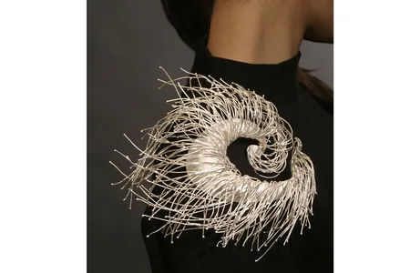 The spiraled crafted work&nbsp;On the Air&nbsp;by Jeong Ju Lee is made to&nbsp;flow with the contour of the model's shoulder.