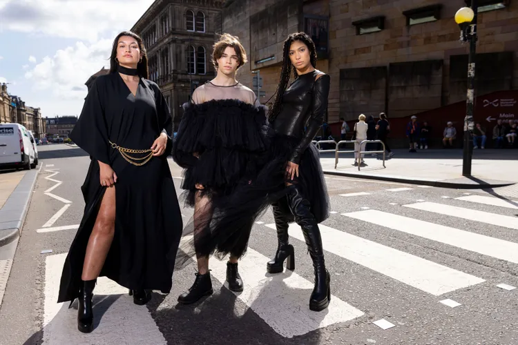 Three models wearing little black dresses