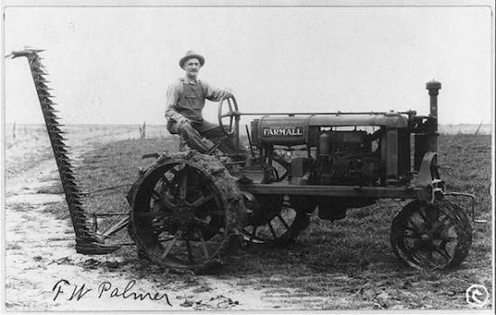 American farmer operating a tractor and reaper