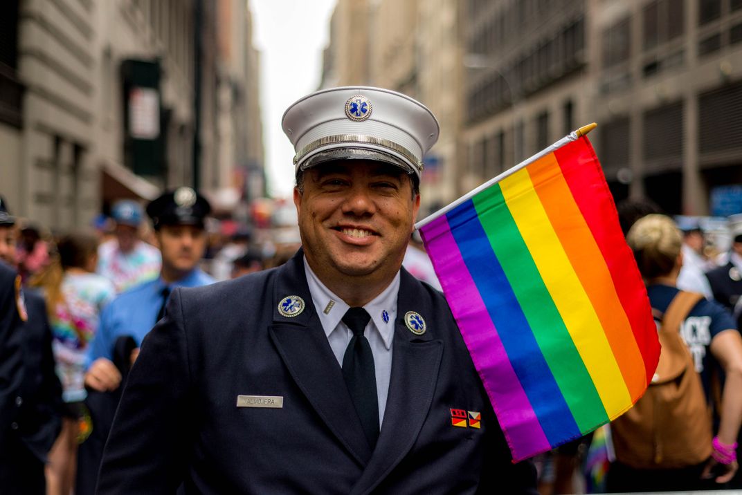 a person in uniform holds a Prde flag