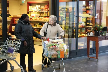 A resident of "Dementia Village" goes grocery shopping with a caregiver.