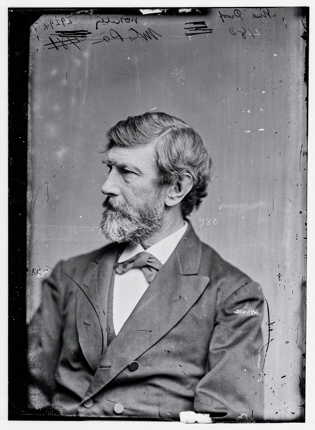 a head and shoulders portrait of a bearded man in a suit
