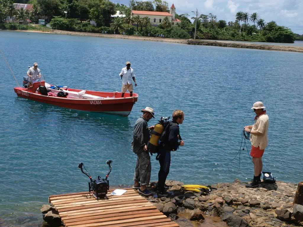 Archaeologists standing next to body of water