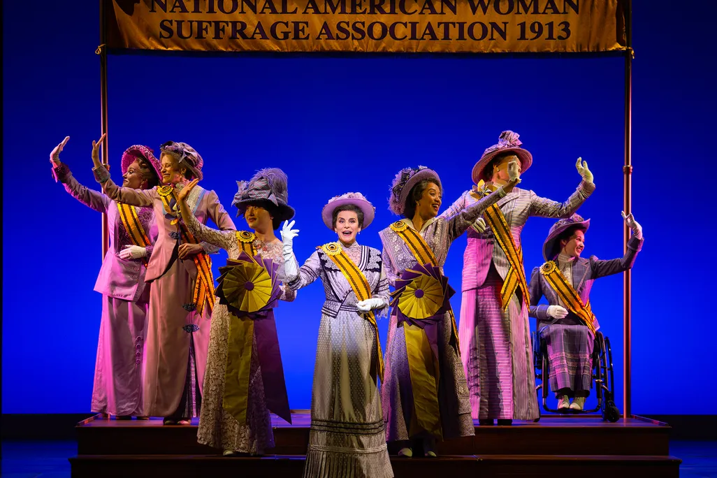 Jenn Colella as Carrie Chapman Catt (center) in Suffs