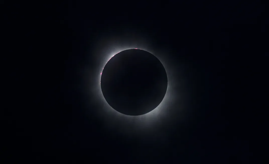 the darkness of totality, with just the corona visible