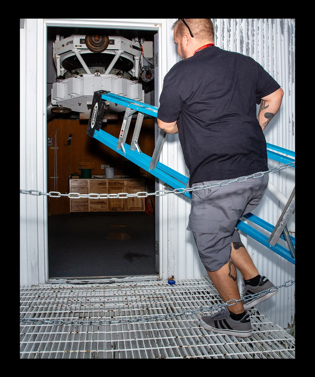 Rankin carries a blue ladder through a door to the observatory