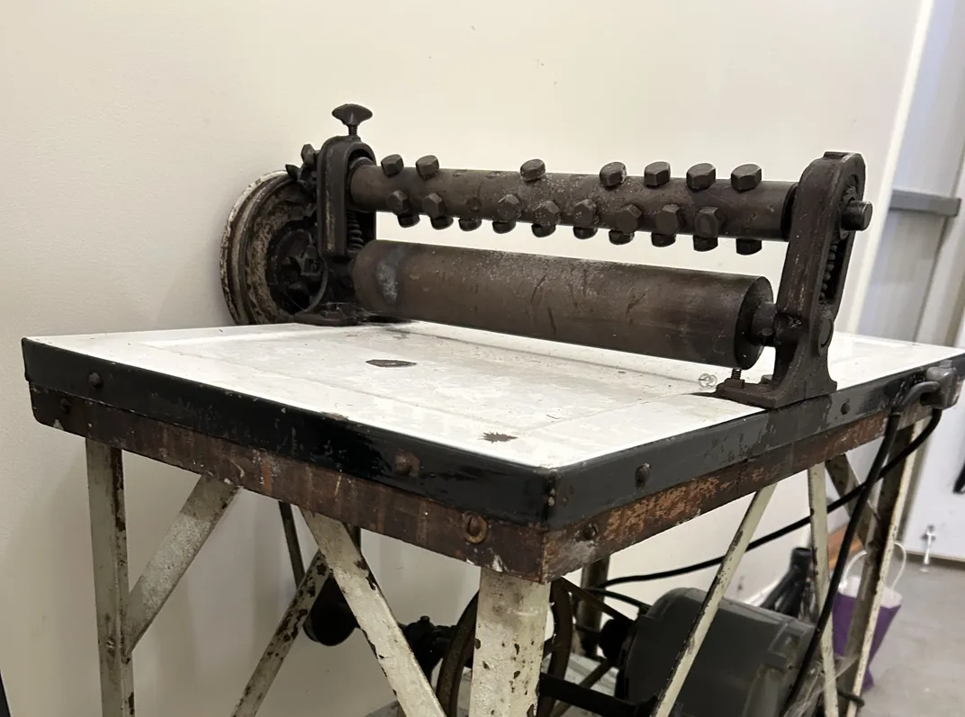 Machine with two rollers atop a counter